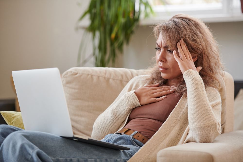 woman on laptop with headache